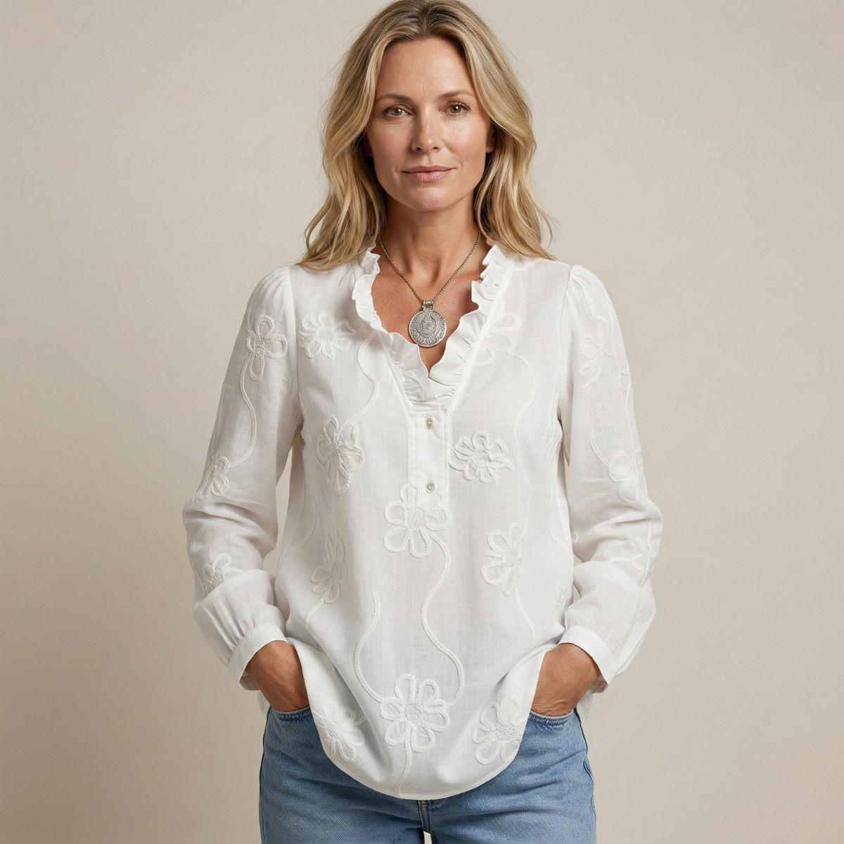 Blusa blanca de algodón con bordado floral y botones al frente, cuello tipo solapa