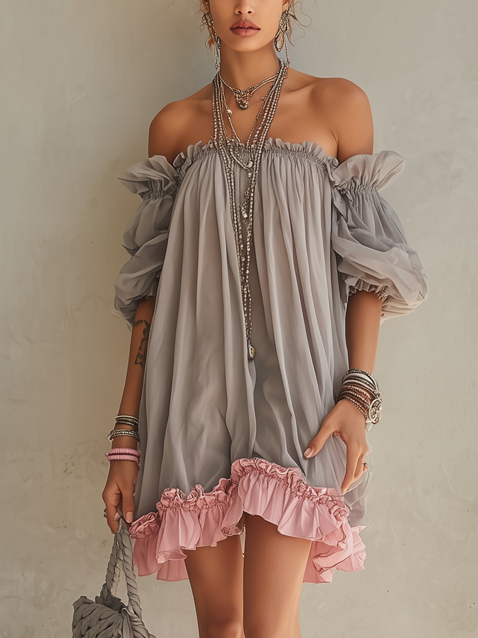 Vestido mini de gasa gris con hombros descubiertos y volante rosa en el bajo