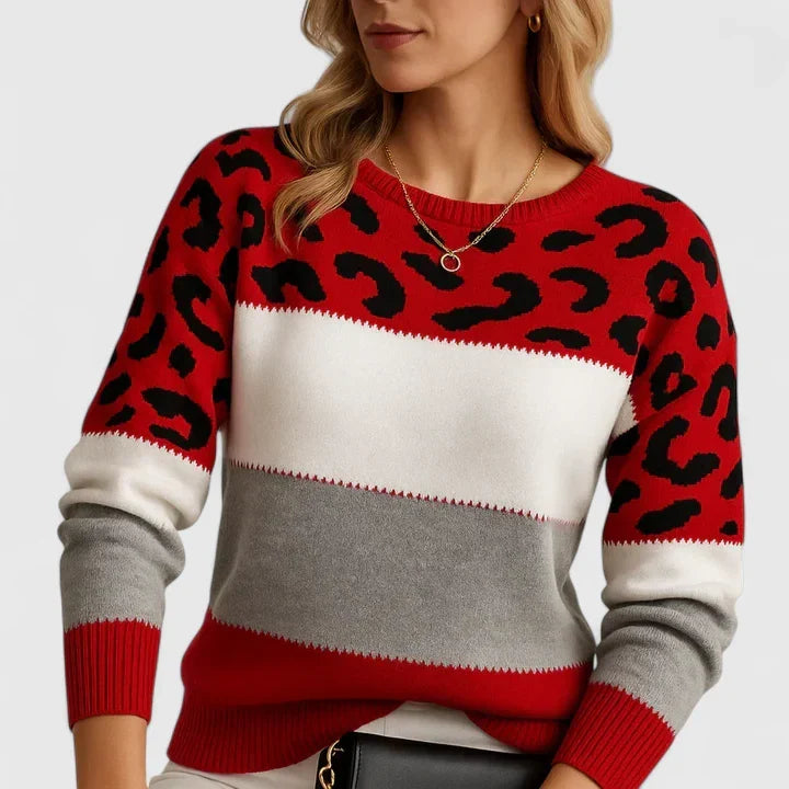 Suéter rojo de punto con estampado animal negro, franjas crema y gris, cuello redondo
