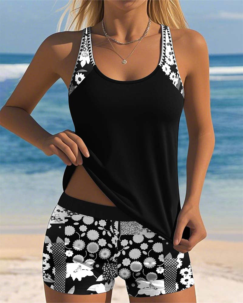 Tankini negra sin mangas con short de baño estampado floral blanco.