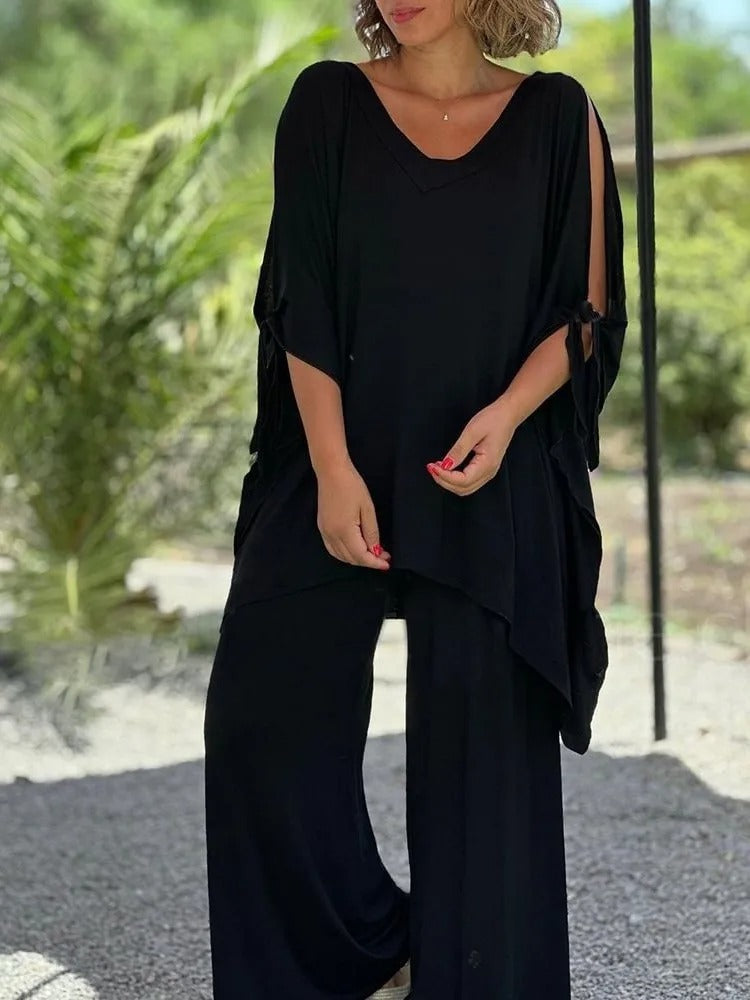 Conjunto negro de túnica con escote pico y mangas caídas con lazos, con pantalón ancho.
