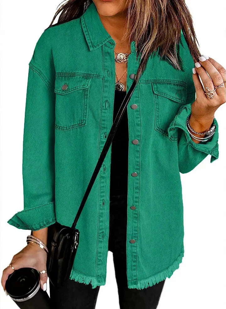 Chaqueta de mezclilla verde con botones, bolsillos frontales y dobladillo con flecos.