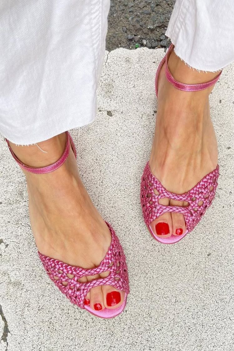 Sandalias fucsia trenzadas con tira al tobillo y lazo en el empeine, punta abierta.