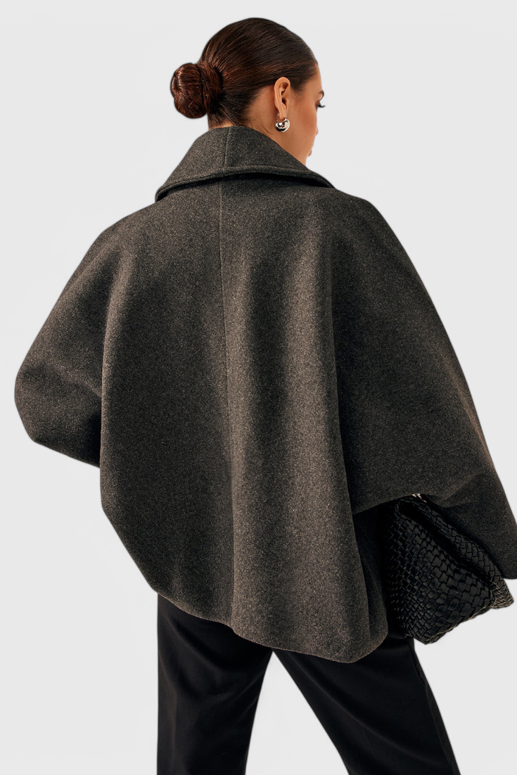 Abrigo de tweed gris oscuro visto por detrás, con manga amplia y caída