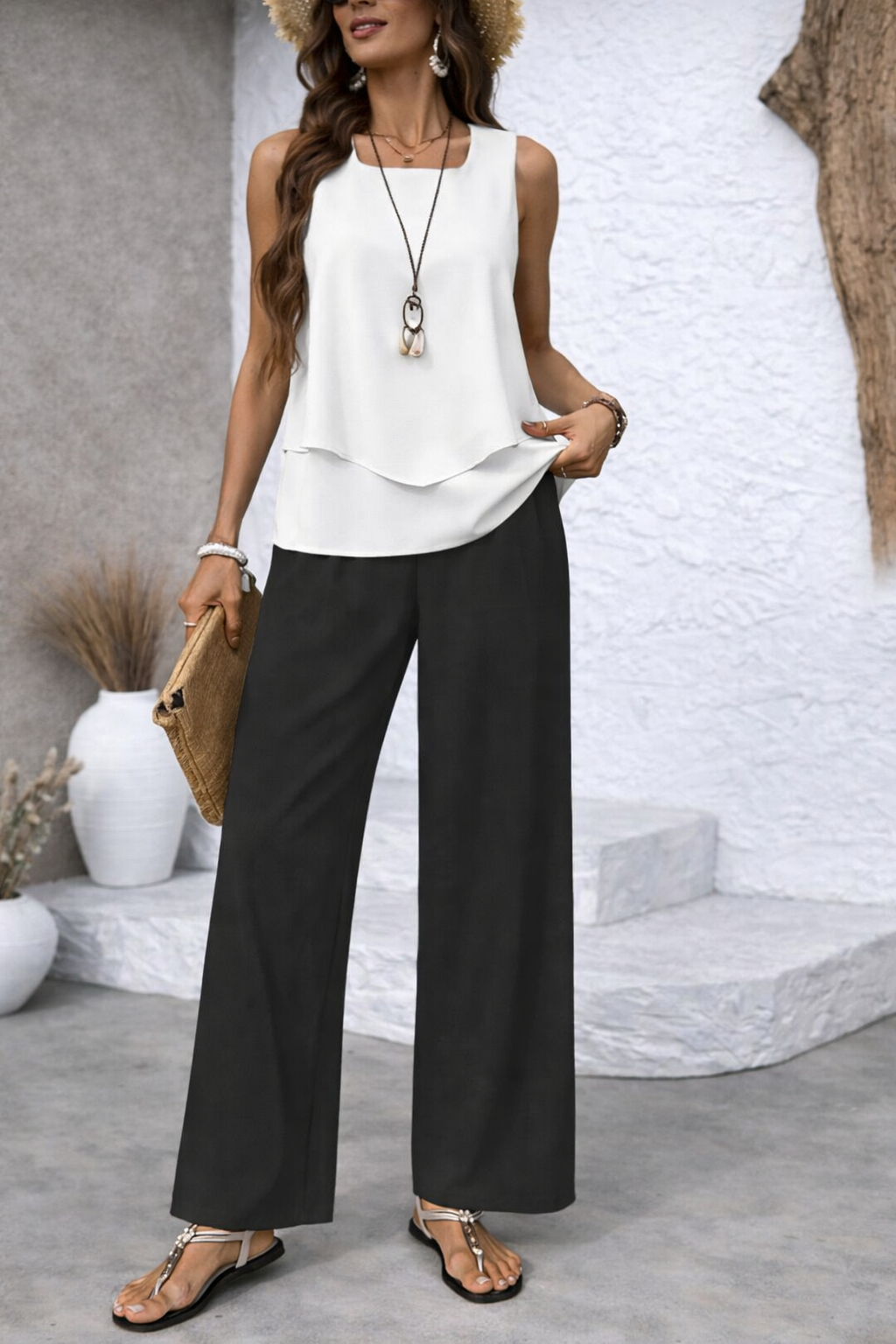 Conjunto bicolor con blusa blanca en capas y pantalón negro de pernera ancha.