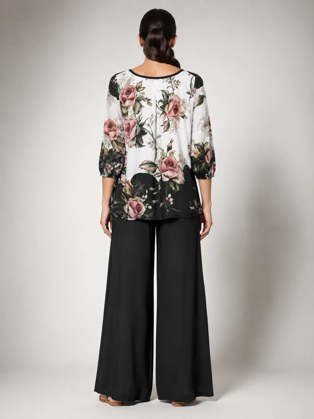 Conjunto con blusa floral estampada y pantalón ancho negro, vista trasera
