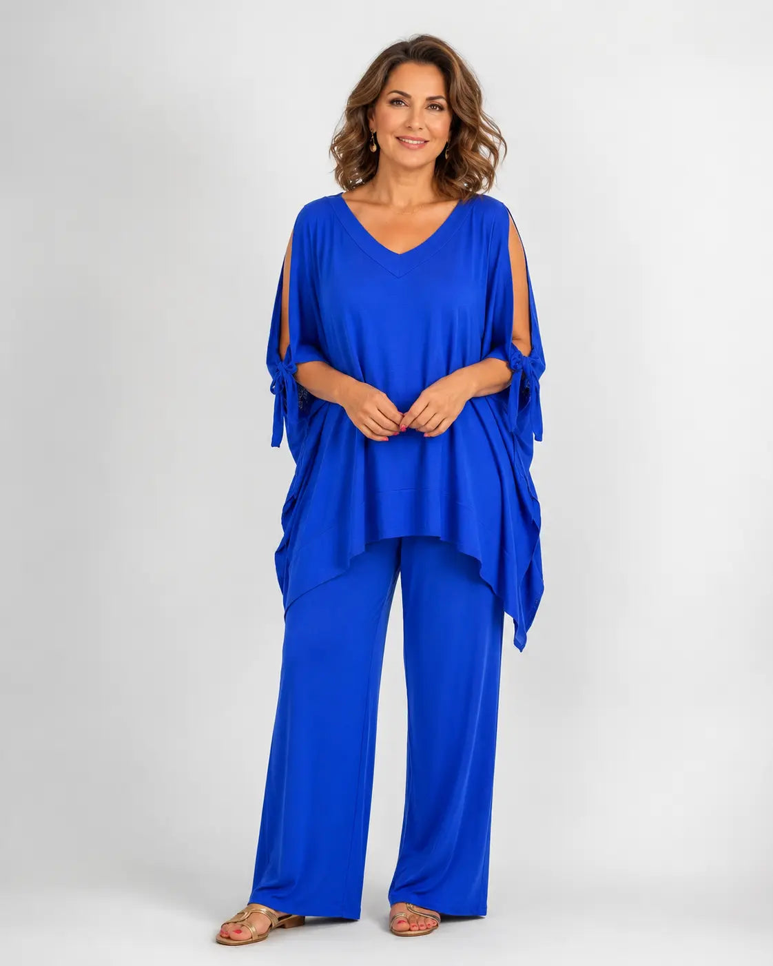 Conjunto de túnica azul con escote pico, hombros descubiertos y pantalón fluido a juego.