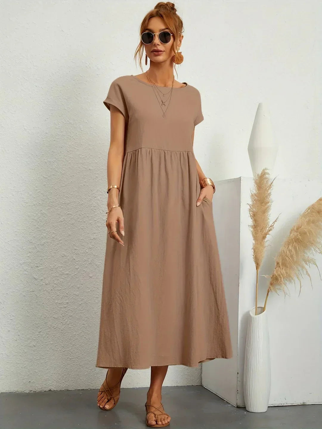 Vestido midi fluido color taupe con cuello redondo, mangas cortas y falda con vuelo