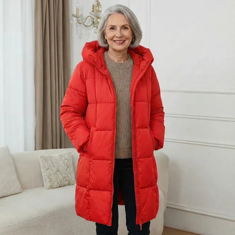 Chaqueta acolchada con capucha roja, cierre frontal y bolsillos laterales.