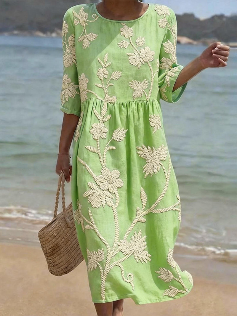 Vestido verde con estampado floral bordado, cintura fruncida y mangas tres cuartos