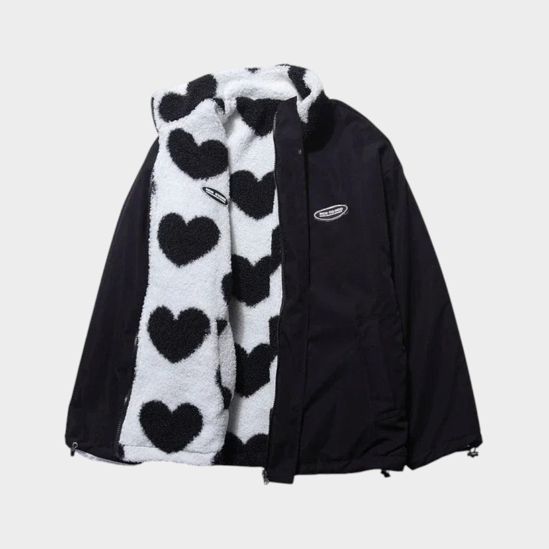 Chaqueta reversible con exterior oscuro y forro polar claro con corazones negros.