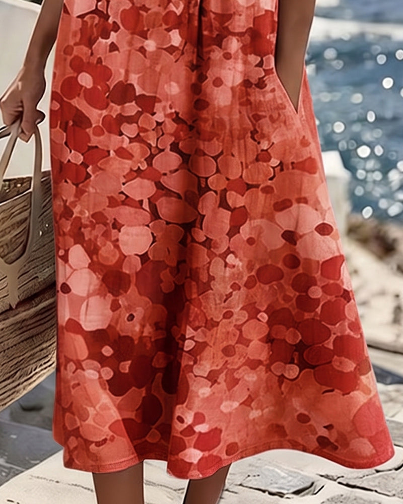 Vestido midi floral rojo con falda amplia; estampado de círculos y pliegues suaves.
