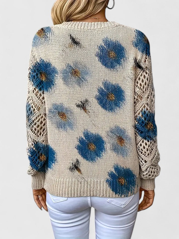 Suéter de punto crema con flores azules y paneles calados en los costados (vista trasera)