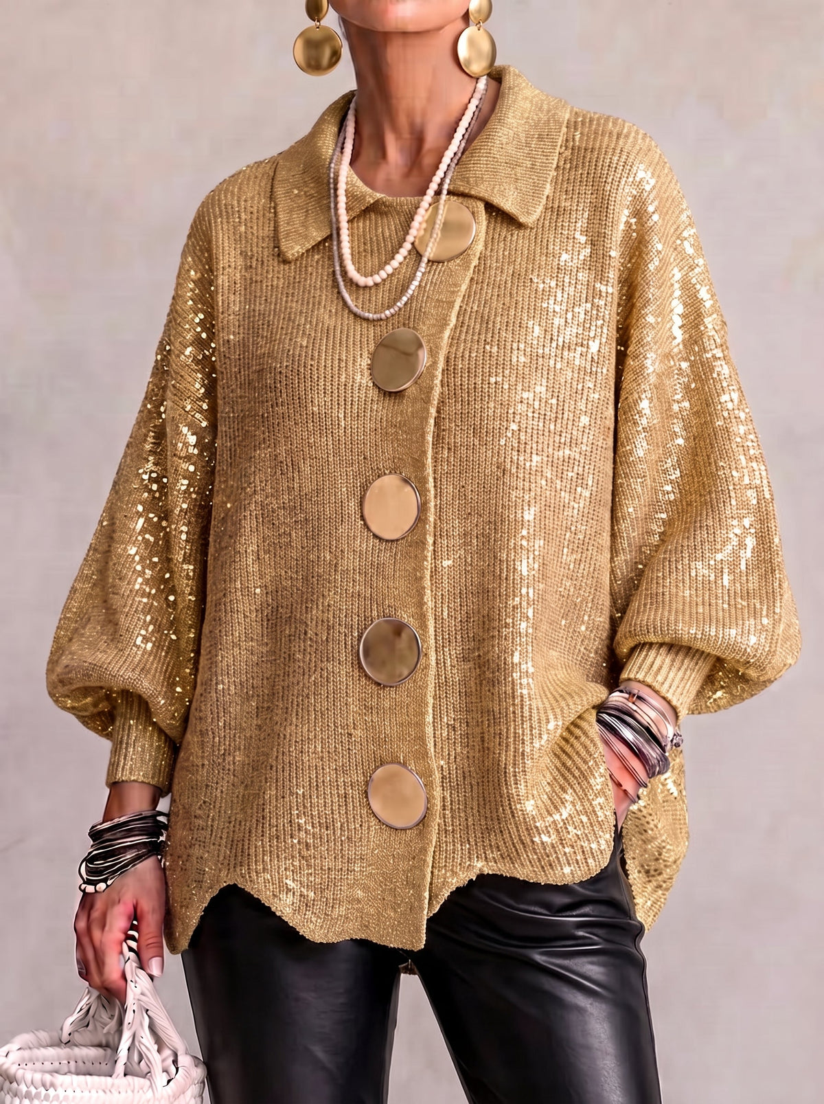 Cárdigan oversize dorado con lentejuelas, cuello y botones metálicos grandes.