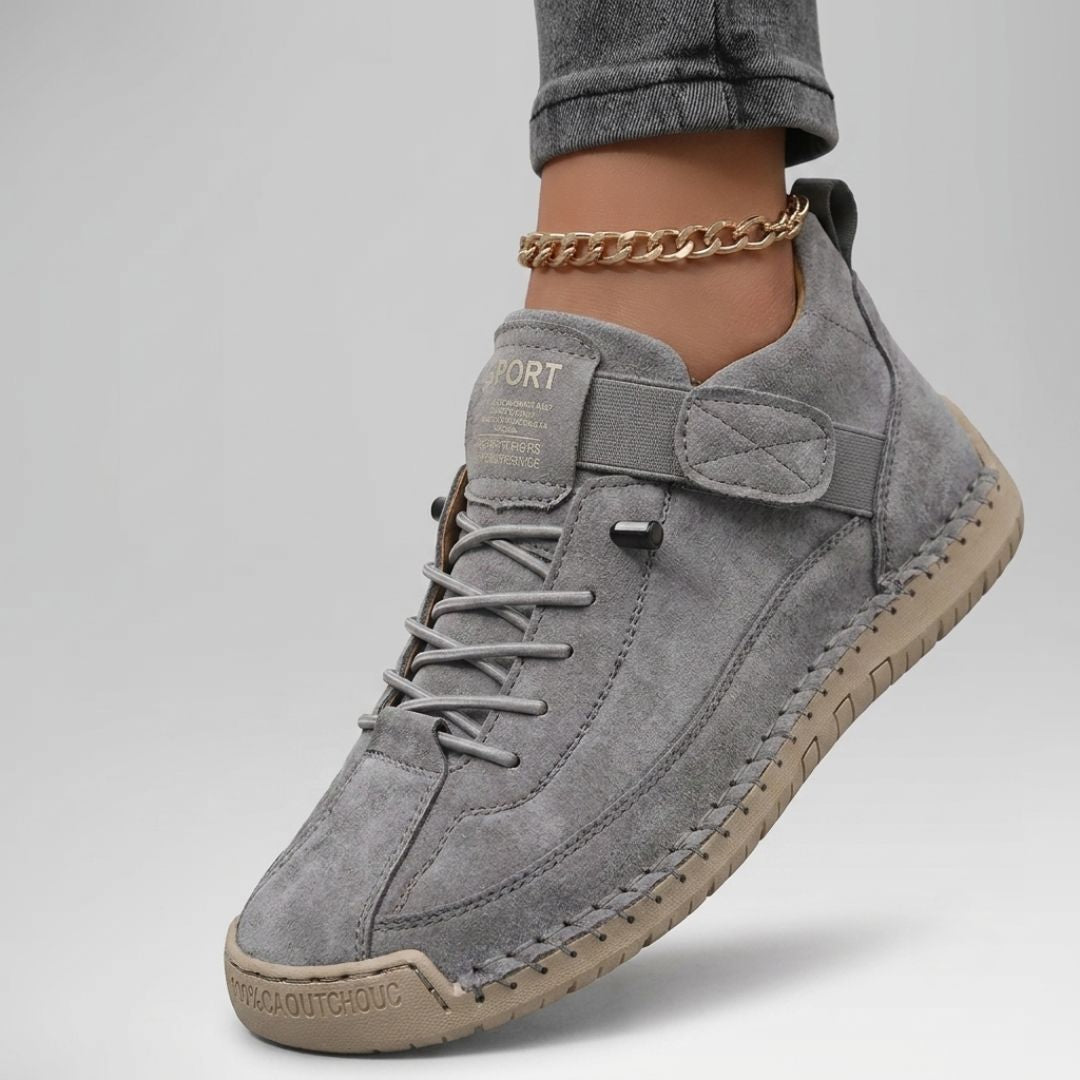 Zapatilla cómoda con soporte gris, cordones y suela con puntadas decorativas