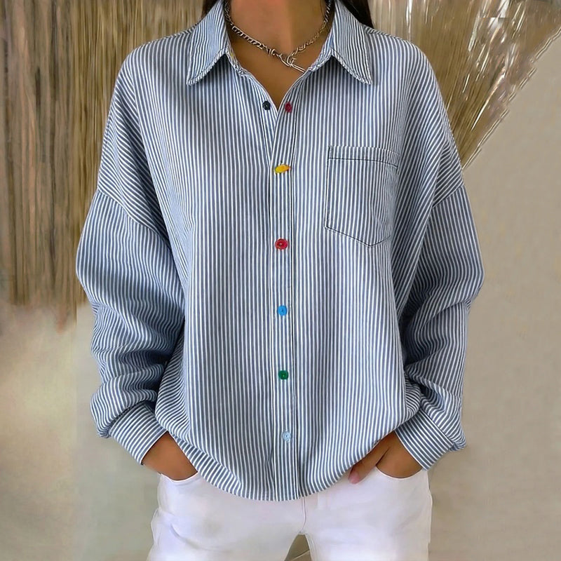 Camisa azul de rayas verticales de manga larga con cuello, botones y bolsillo delantero