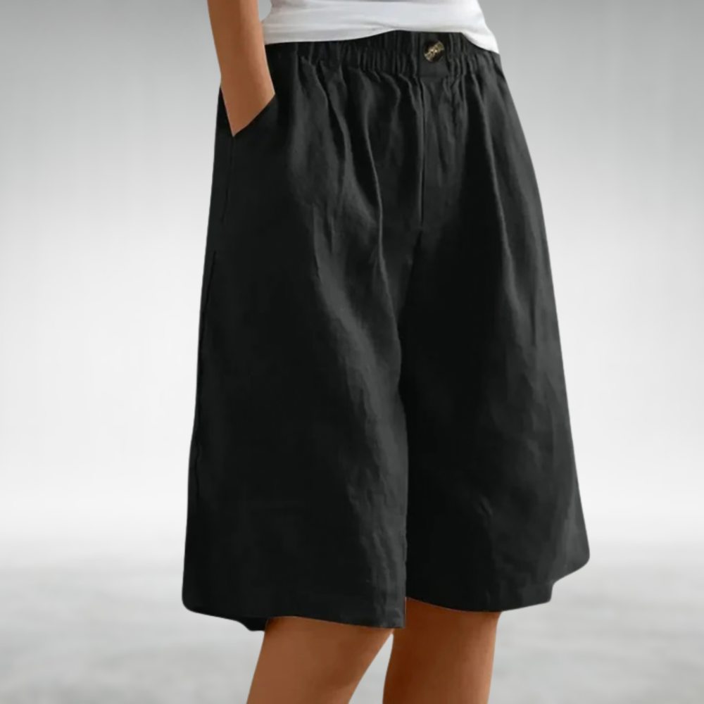 Shorts cómodos negros con cintura elástica y botón metálico frontal. Largo a la rodilla.