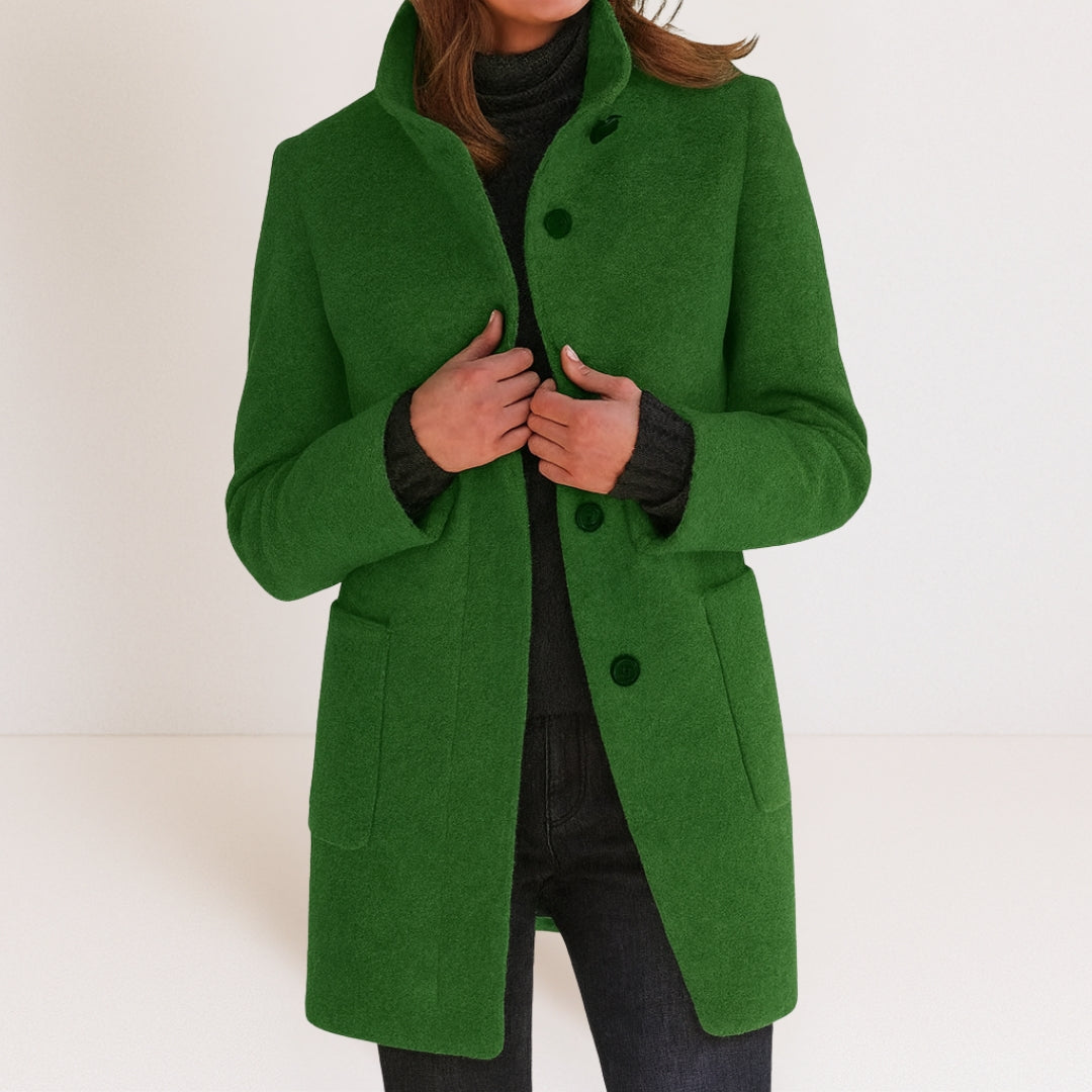 Chaqueta de mujer verde con cuello alto, botones frontales y bolsillos tipo parche.