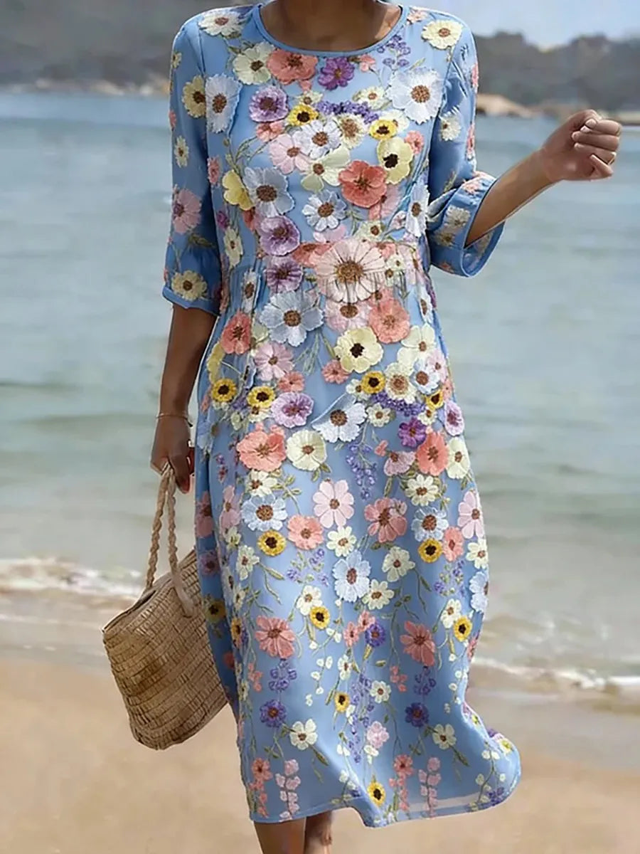 Vestido midi azul claro con estampado floral multicolor, manga 3/4 y silueta recta.