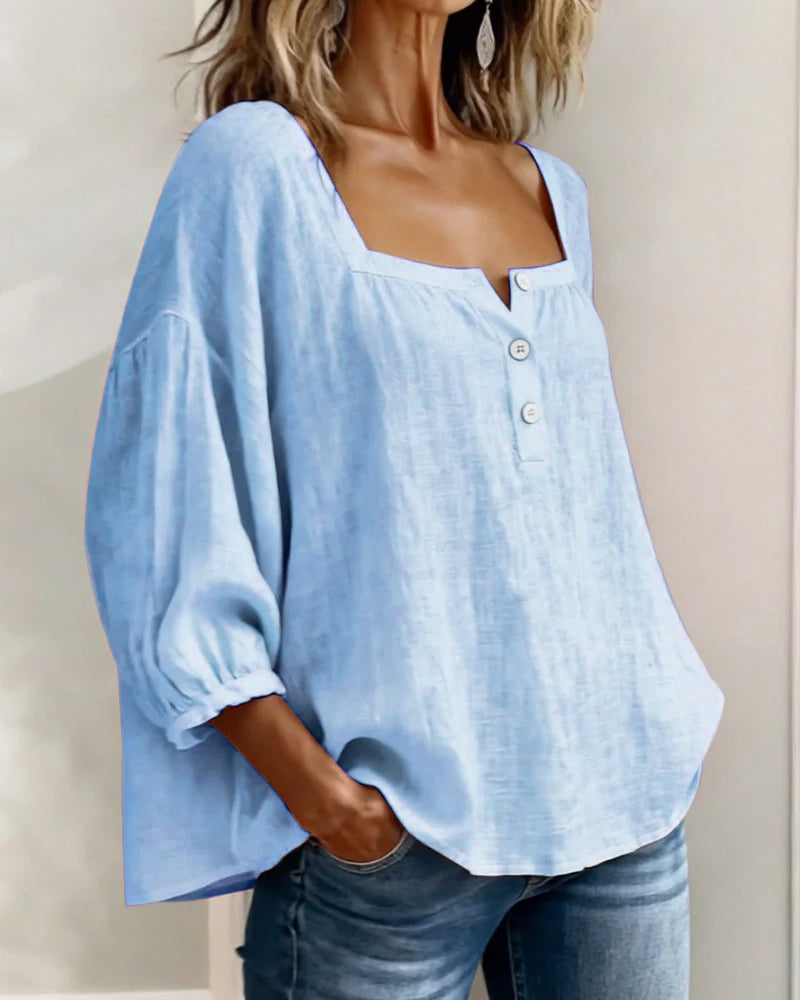 Blusa de lino azul claro con botones al centro y mangas abullonadas