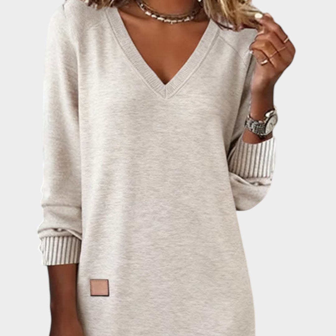 Vestido de punto beige con cuello pico y mangas 3/4; puños a rayas