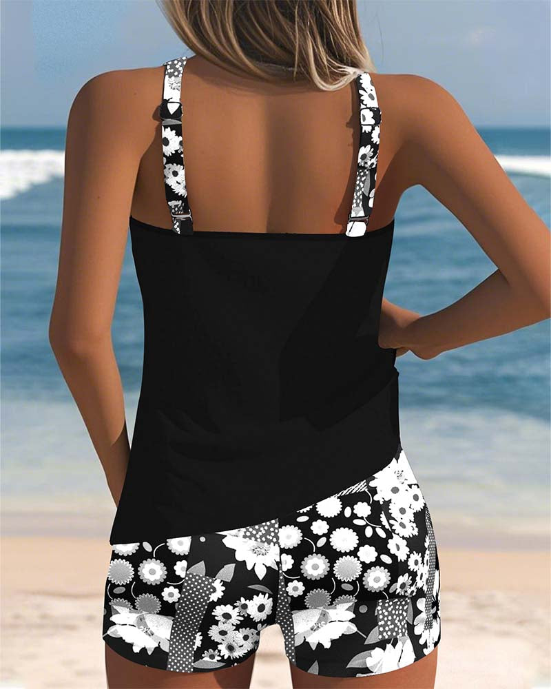 Tankini negra sin mangas con short de baño estampado floral blanco, vista trasera.