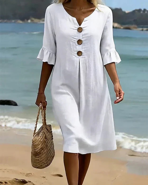 Vestido blanco con botones de madera y falda recta hasta la rodilla, mangas con volante