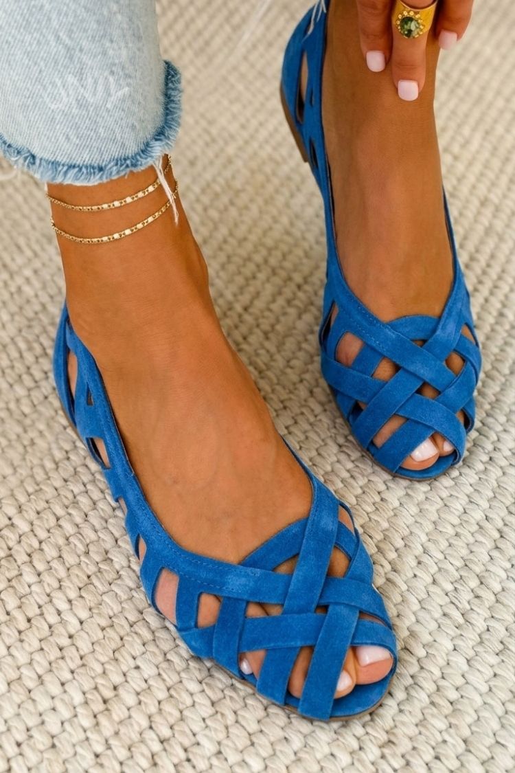Sandalias planas trenzadas azules con tiras cruzadas y punta abierta.