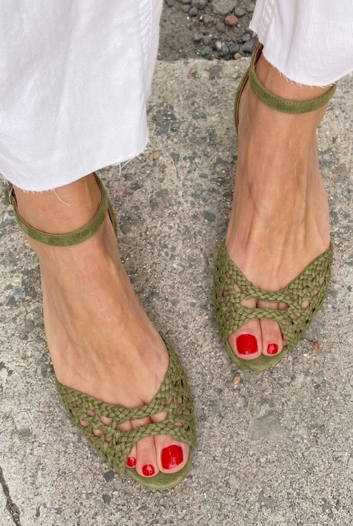Sandalias verdes trenzadas con tira al tobillo y lazo en el empeine, punta abierta.