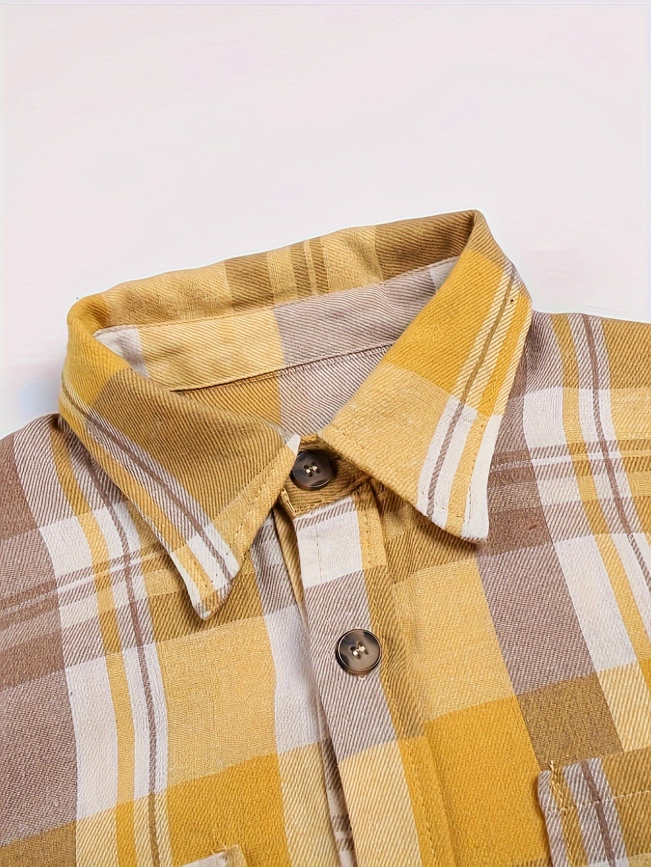 Cuello de camisa de cuadros amarillos y blancos con botones y abertura frontal.