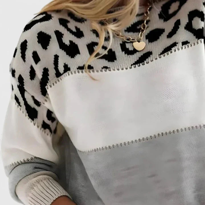 Suéter blanco de punto con estampado animal negro y franjas grises en el torso