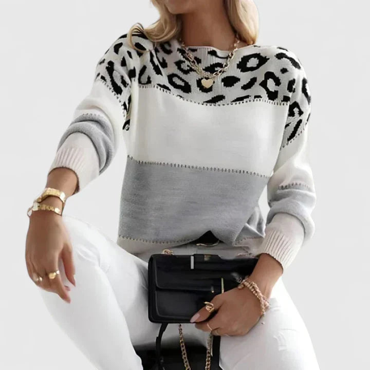 Suéter blanco de punto con estampado animal negro y franjas grises, cuello redondo