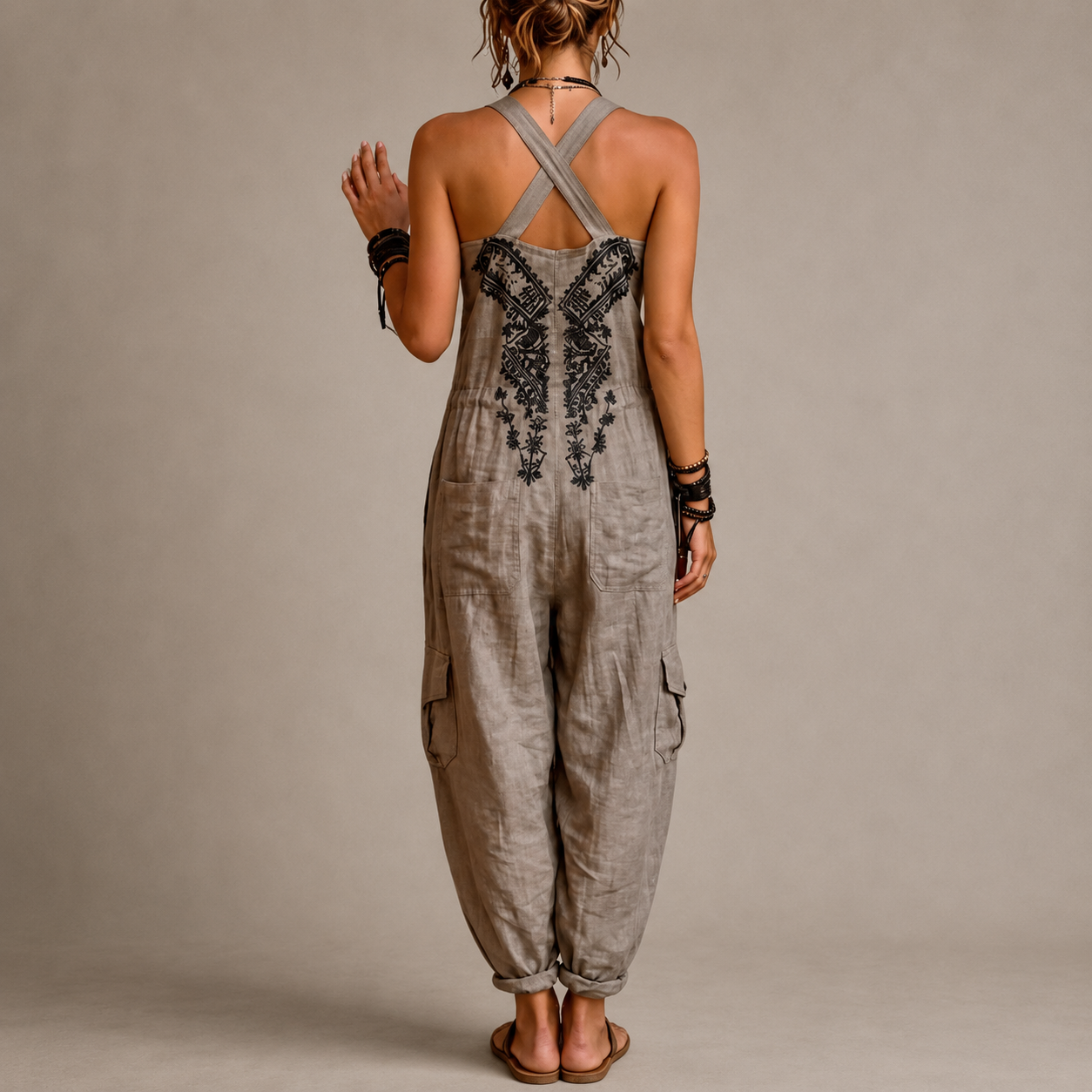 Mono bohemio gris con espalda cruzada en X, bordado central y pantalón suelto tipo globo