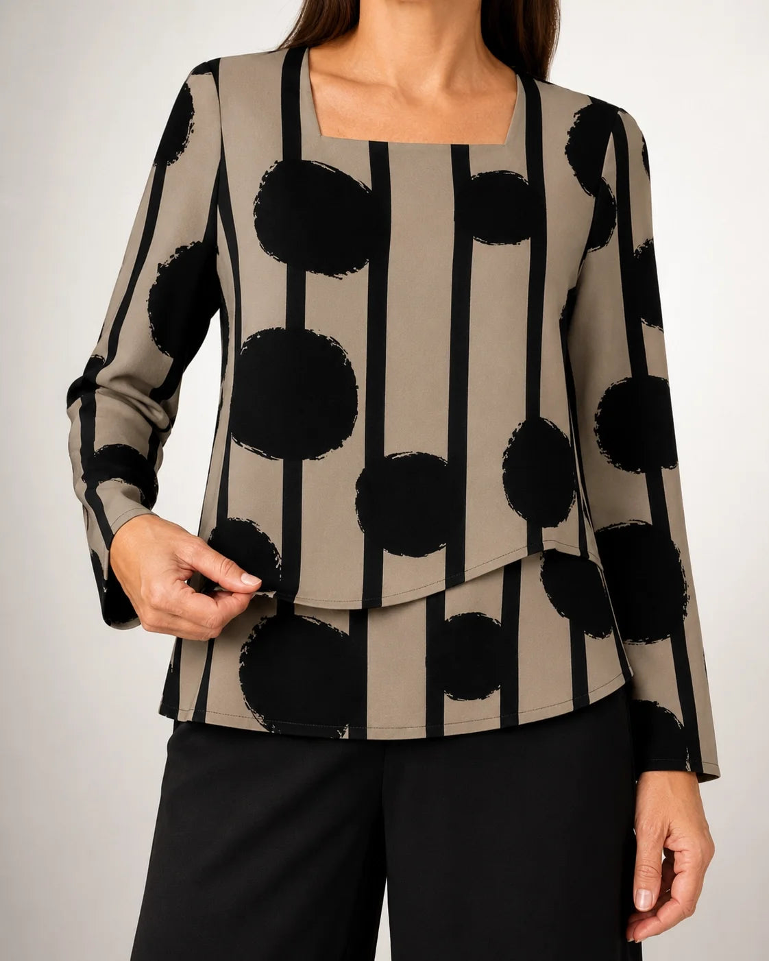 Blusa cuadrada de lunares negros y rayas con pantalón negro de pierna ancha