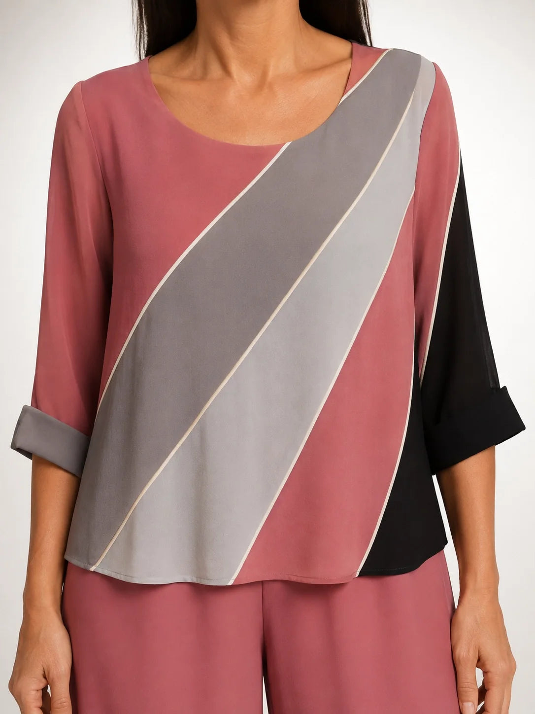 Blusa suelta rosa con franja diagonal gris y detalles negros, corte asimétrico