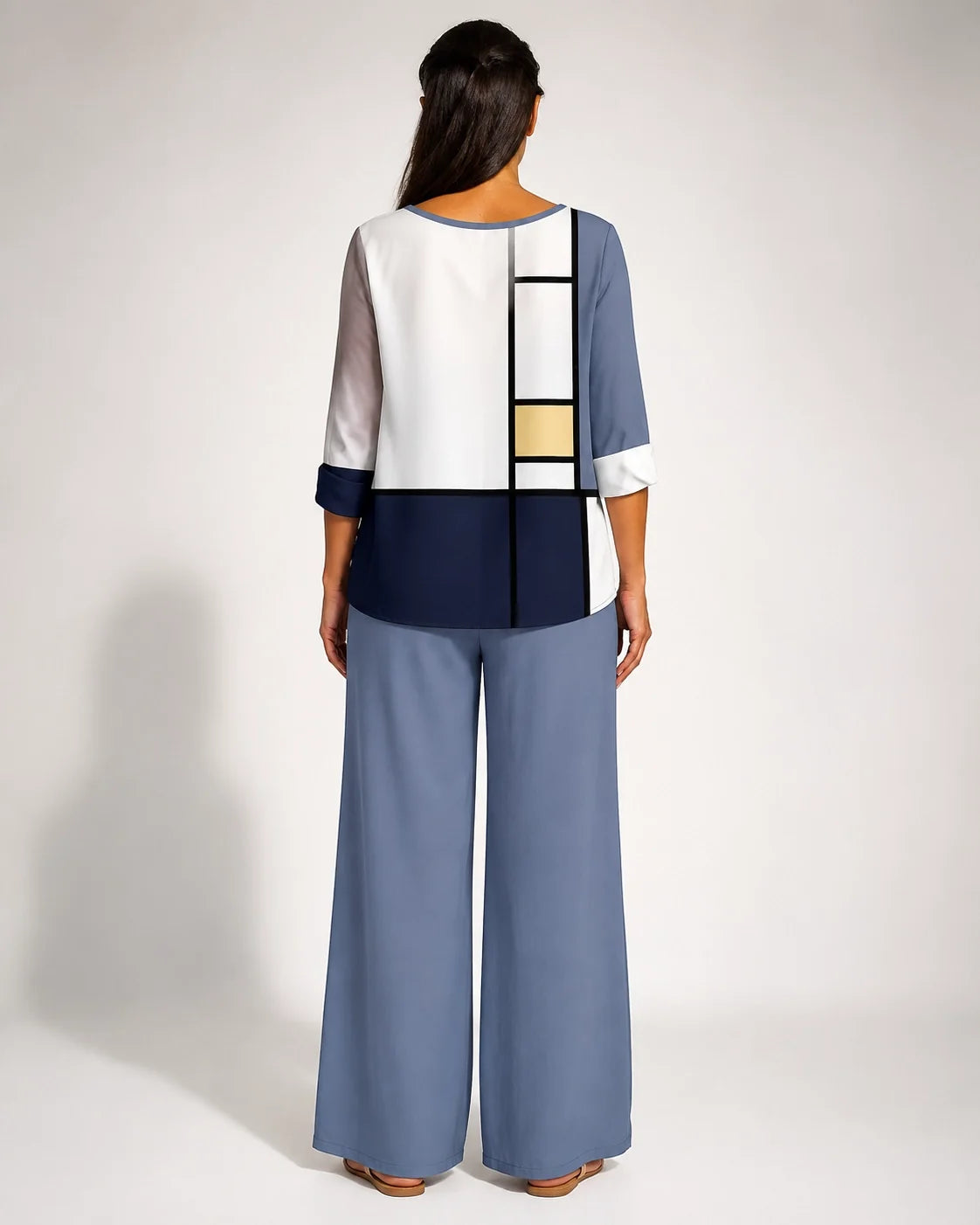Conjunto geométrico por detrás: blusa blanca con paneles y pantalón azul de pernera ancha