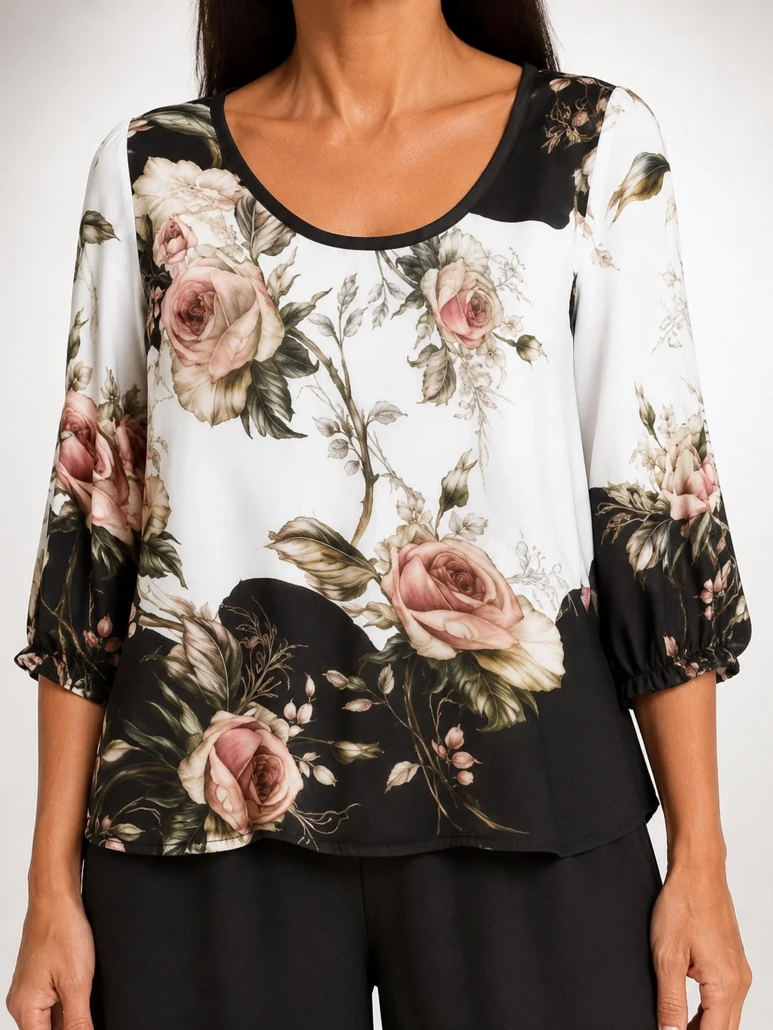 Blusa floral negra y rosa con escote redondo y mangas abullonadas, bajo con volante