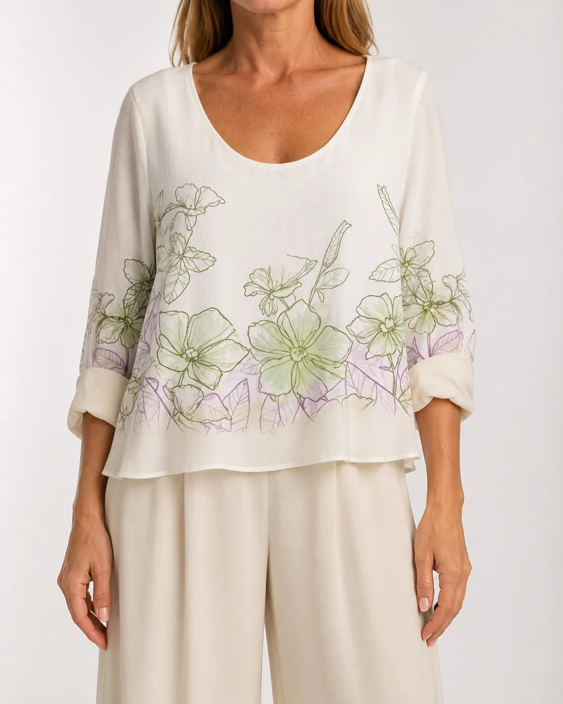 Blusa holgada blanca con estampado floral verde y detalle lila en el bajo