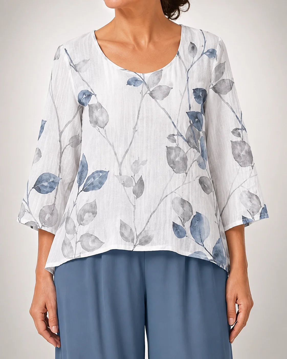 Blusa blanca con estampado floral azul y gris sobre pantalón azul marino