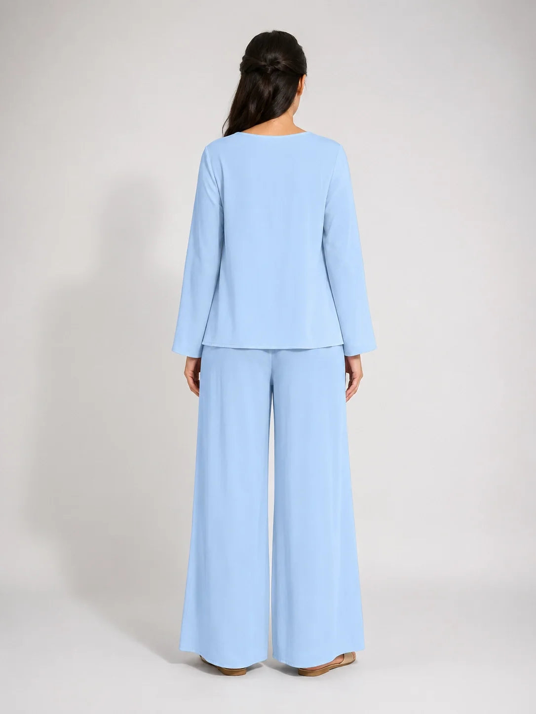 Conjunto azul claro a la espalda: blusa con manga tres cuartos y pantalón ancho