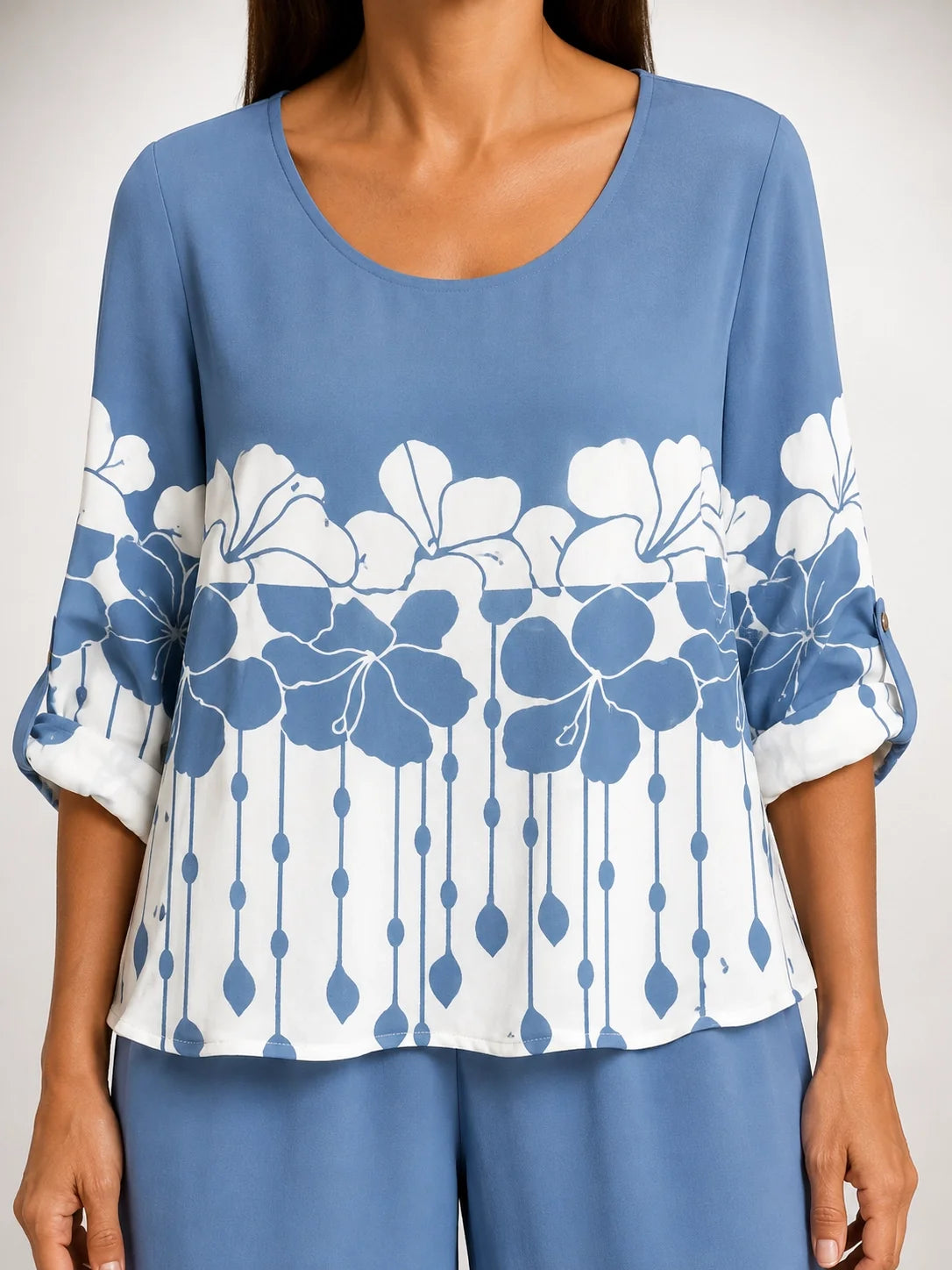 Blusa azul con flores blancas y mangas abullonadas; parte inferior con rayas