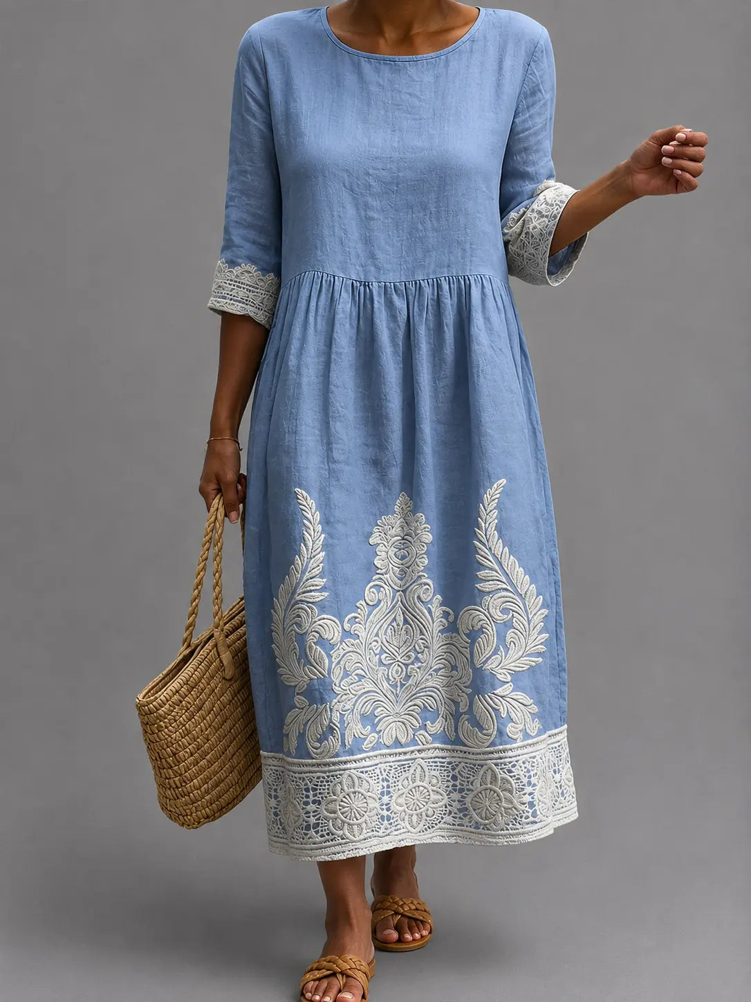 Vestido informal azul con manga 3/4, cintura fruncida y estampado floral en el bajo.