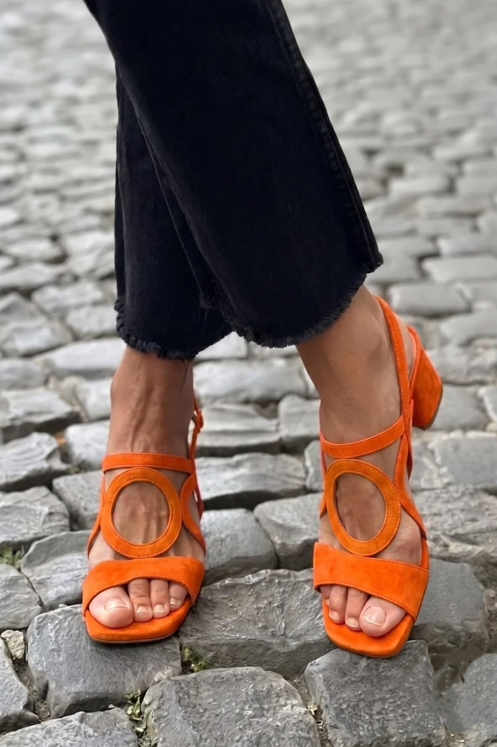 Sandalias planas Begoña con detalle circular en ante naranja, diseño de tiras cruzadas