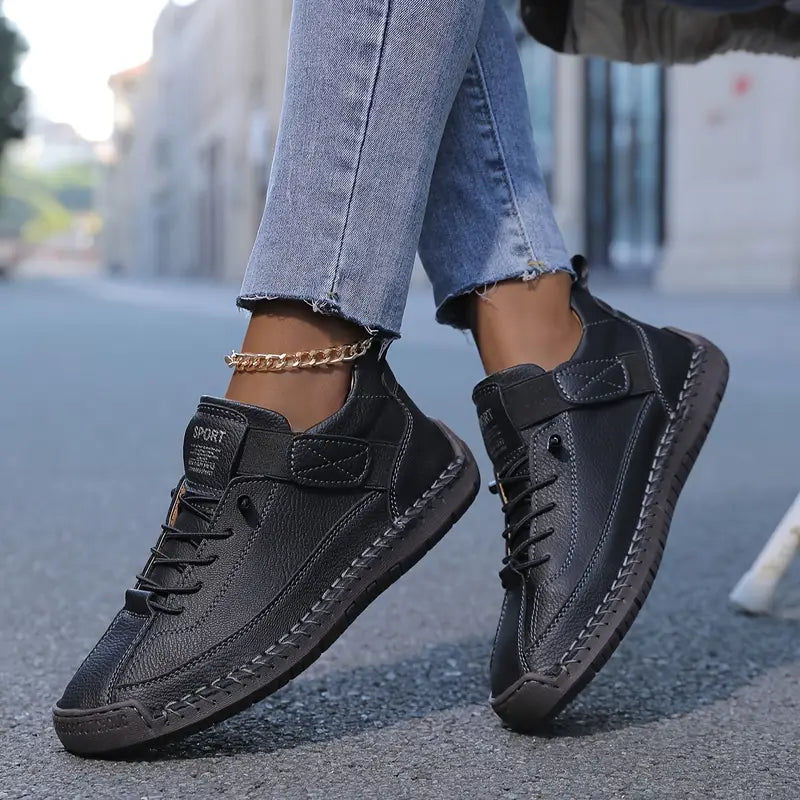 Zapatilla cómoda con soporte negra, cordones y suela con costuras decorativas