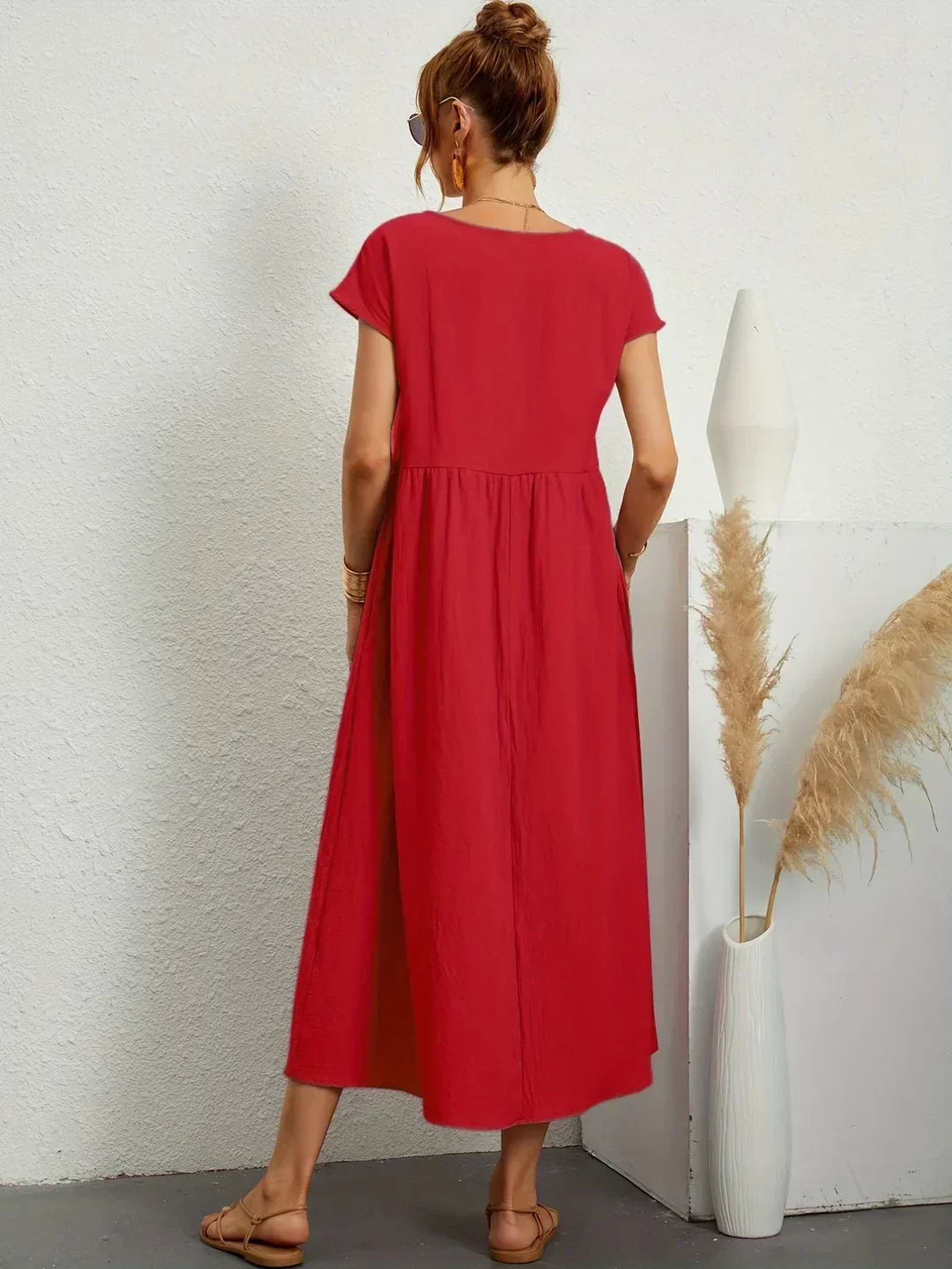 Vestido midi fluido rojo visto por la espalda, mangas cortas y falda con vuelo