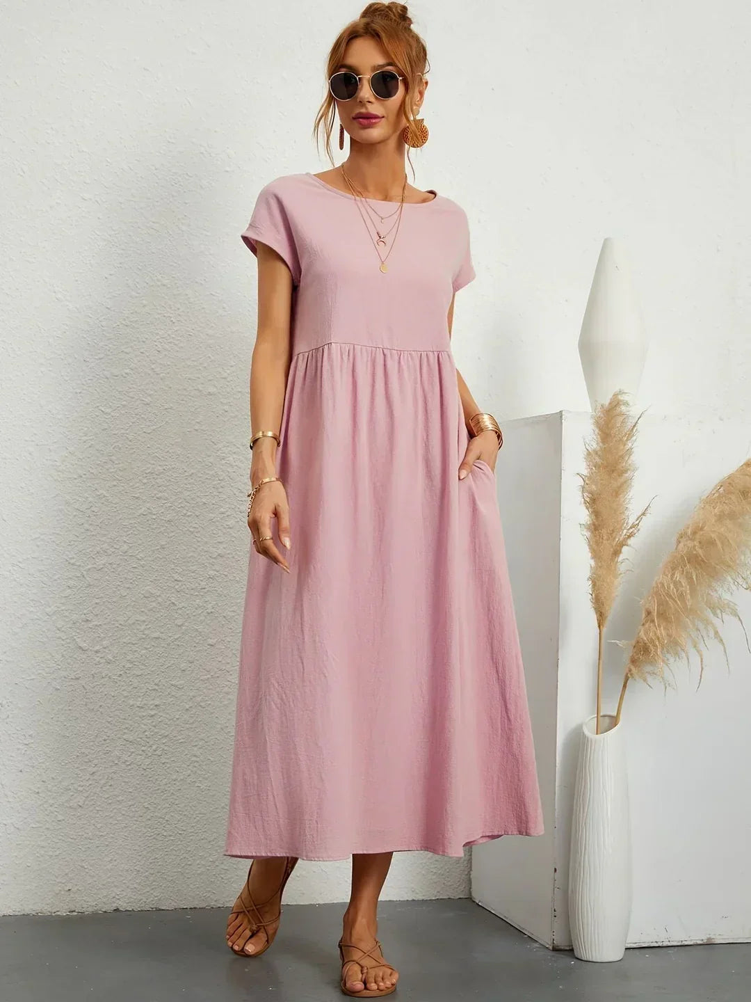 Vestido midi fluido rosa con cuello redondo, mangas cortas y falda con vuelo