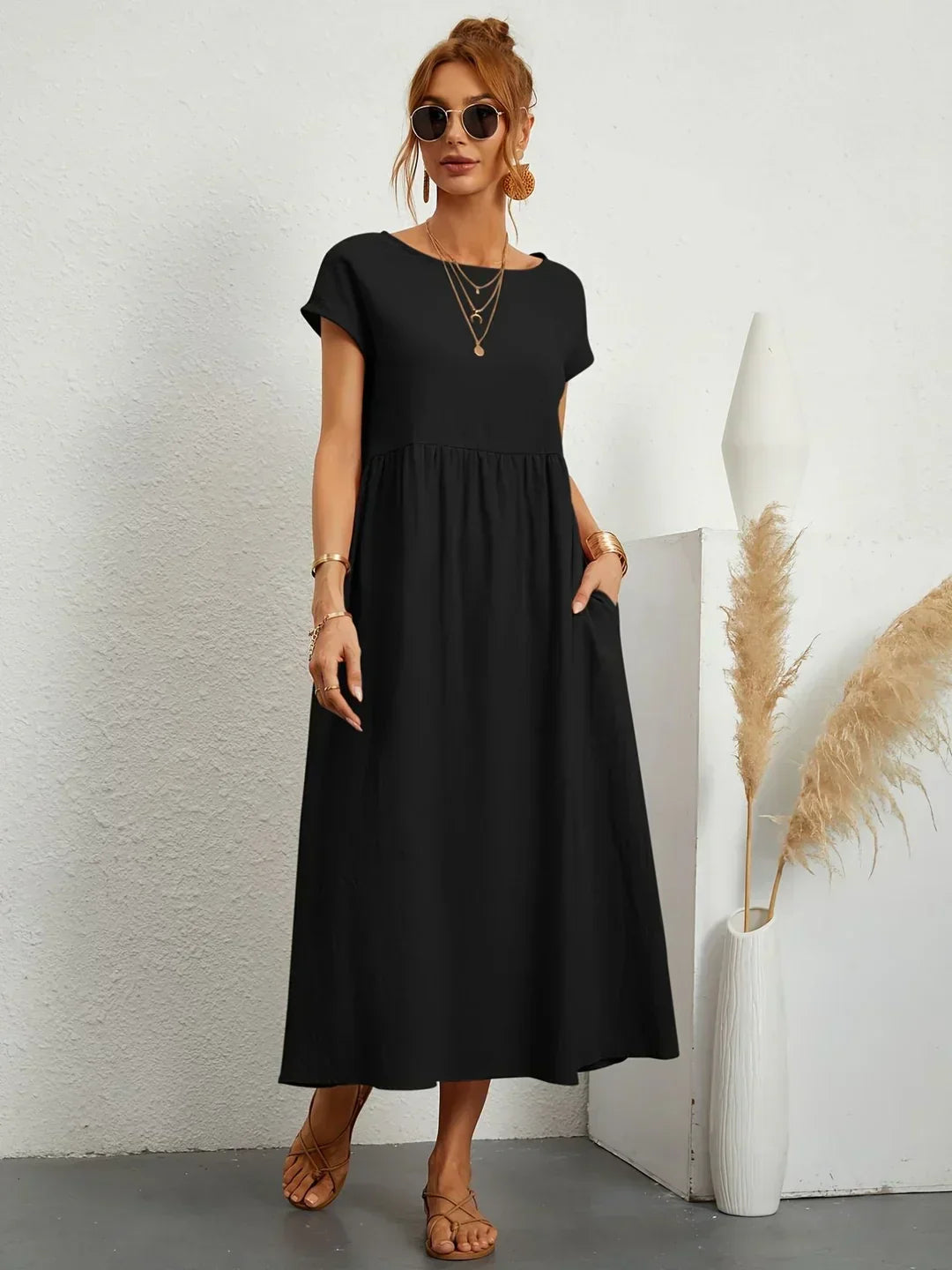 Vestido midi fluido negro con cuello redondo, mangas cortas y falda fruncida