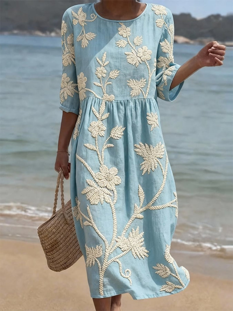 Vestido azul con estampado bordado floral, talle fruncido y manga tres cuartos
