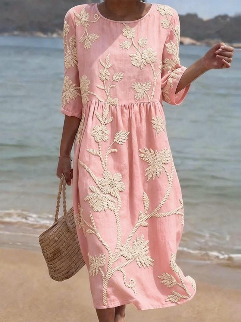 Vestido rosa con bordado floral, manga 3/4 y cintura fruncida con caída
