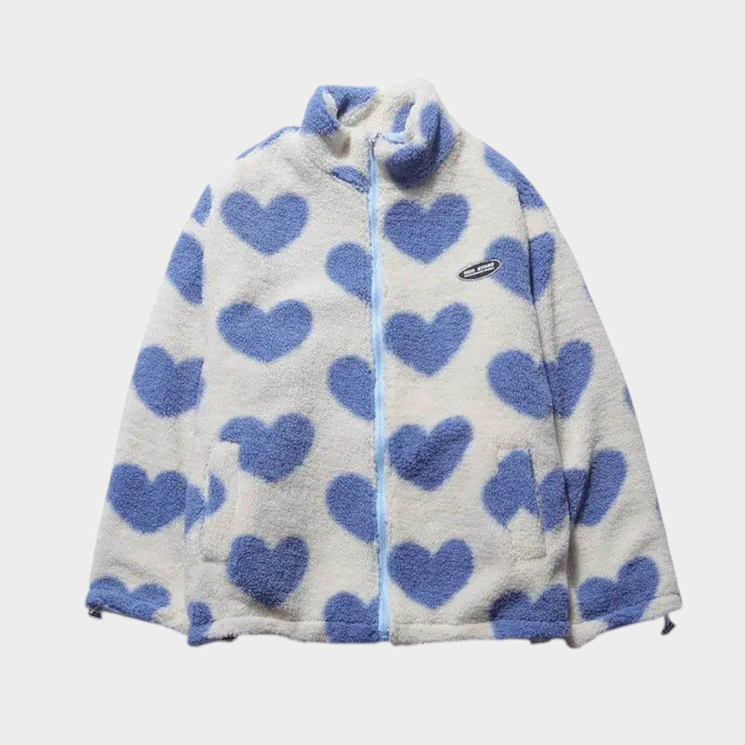 Chaqueta reversible de forro polar claro con corazones azules y cierre frontal.
